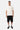 T-shirt Joums Écru porté par un mannequin homme en pied avec short noir et baskets, broderie Eleven sur la poche