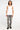 Pantalon Beleo Gris en pied sur mannequin homme avec débardeur blanc et baskets noires, fleurs de lys noires brodées