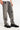 Pantalon Beleo Gris vu de trois quarts sur mannequin, fleurs de lys noires brodées sur denim gris