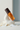 Brume parfumée Chill Vibes Eleven Paris, flacon orangé à bouchon brun, cœur smiley No Snitch, posé sur un galet blanc