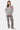Pantalon Flex Gris porté en pied par une mannequin femme avec pull gris, fleurs de lys roses brodées, baskets