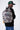 Sac à dos Egan Noir délavé effet tie-dye gris porté de dos par un mannequin homme, avec porte-clés colorés