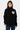 Pull Emile Noir à col montant porté de face par une femme, coeur smiley écru sur la poitrine