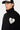Pull Emile Noir à col montant en gros plan porté par un homme, grand coeur écru avec visage smiley