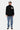 Jean Flex Bleu Jean porté en pied par un homme, motifs fleurs de lys bleus, avec pull noir et baskets