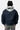 Blouson Eschott Bleu marine porté de dos par une mannequin femme, capuche grise brodée d'un cœur et d'une inscription