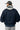 Blouson Eschott Bleu marine porté de dos par un mannequin homme, capuche grise ornée d'un cœur bleu marine brodé