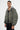 Blouson Eschott Kaki porté de trois quarts par un mannequin homme, poche de manche zippée et pantalon cargo noir