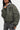 Blouson Eschott Kaki en plan rapproché sur mannequin femme, écusson cœur brodé, patch et poche de manche zippée