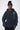 Sweat à capuche Evy Noir Délavé porté de face par un mannequin homme coiffé d'un bonnet noir, trois cœurs smiley