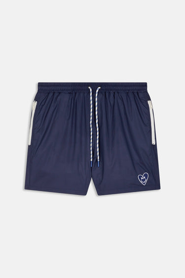 Maillot de bain Nibby Bleu nuit de face à plat, bandes blanches aux poches, cordon et petit coeur blanc brodé