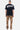 T-shirt Fabea Noir porté de dos par un mannequin homme en pied, grand logo Eleven Paris blanc, pantalon cargo camouflage