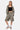 Short Jiora Kaki porté en pied par une femme avec brassière noire et veste zippée assortie, fleurs de lys