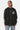 Sweat à capuche zippé Filona Noir porté de face par une mannequin femme, emblème fleur de lys blanc sur la poitrine