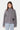 Cardigan zippé Finlande Gris en maille côtelée porté de face par une mannequin, col montant, poche ornée d'un cœur noir