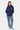Pantalon Flex Bleu Jean porté de face par une mannequin avec sweat à capuche bleu marine, fleurs de lys sur les jambes