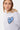 Sweat à capuche Fontenay Gris Chiné, gros plan sur le coeur bleu à yeux en croix et les cordons, porté par une femme