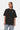 T-shirt Foufou Noir porté par une femme, de face, coupe oversize, coeur blanc brodé et jean clair