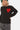 Pull en maille Franklin Noir, gros plan de face sur le coeur rouge brodé à yeux en croix, porté par un enfant