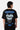 T-shirt Jais Noir vu de dos sur un mannequin homme, cœur Eleven Paris blanc et inscription ELVN Design Studio bleue