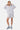 Sweat à capuche zippé Jalya Gris Chiné porté en pied par une mannequin femme avec short assorti et baskets bleues