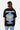 T-shirt Jamaica Noir vu de dos sur une mannequin femme, grande fleur bleue souriante et texte Melrose Avenue
