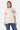 T-shirt James Écru oversize porté de face par une mannequin femme avec jean bleu, 22 bleu et bandes roses