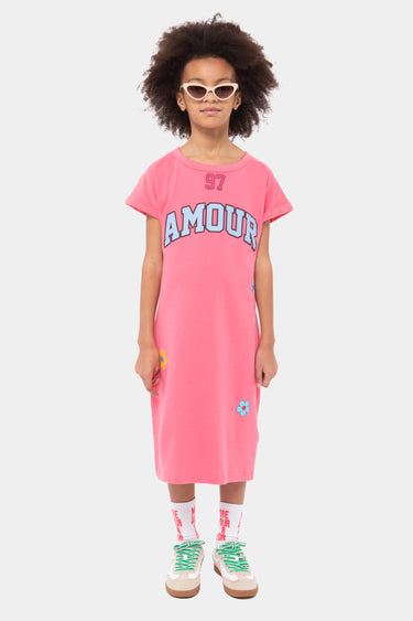 Robe enfant Jamour Rose portée en pied par une fille avec lunettes claires, inscription Amour bleue style universitaire