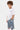 T-shirt enfant January Blanc porté de profil par un garçon, inscription Eleven noire et short en jean à fleurs de lys