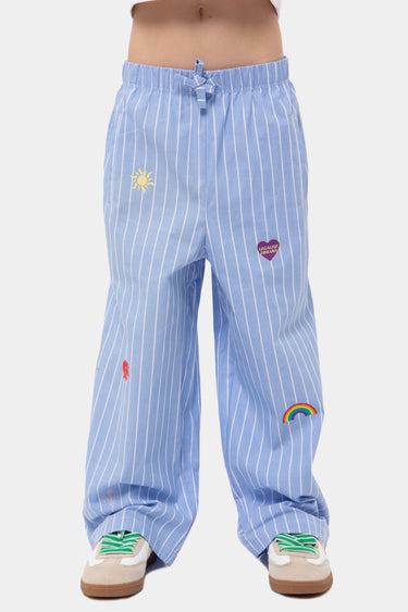 Pantalon Jasmin Bleu rayé large porté par un enfant, de face, soleil, coeur et arc-en-ciel brodés