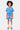 Short Julie Bleu porté par un enfant, de face, lettres roses gothiques Eleven sur les jambes et cordon blanc