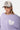 Pull Jedmo Lilas porté par une mannequin femme, gros plan, casquette blanche brodée, coeur blanc à croix lilas