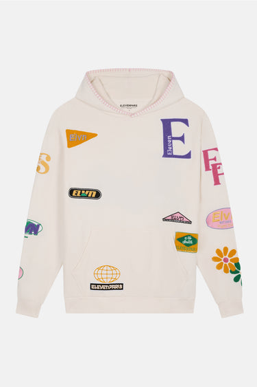 Sweat à capuche Jenna Écru à plat, de face, lettre E violette, écussons colorés et fleurs sur les manches