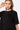 T-shirt Jerusalema Noir porté par une mannequin femme, gros plan de face, coeur noir en relief à croix brodées