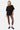T-shirt Jerusalema Noir oversize porté par une mannequin femme en pied, legging imprimé marron, baskets noires