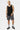 Maillot de bain Jibby Noir à motif cachemire blanc porté par un mannequin homme en pied, de face, chaussettes rayées 03