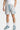 Maillot de bain Jibby Écru motif paisley bleu, vue de face portée, cordon de serrage bleu et baskets bleues