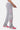 Jogging Jill Gris Chiné porté de profil, trois cœurs à croix rose, blanc et rouge sur la jambe, baskets roses