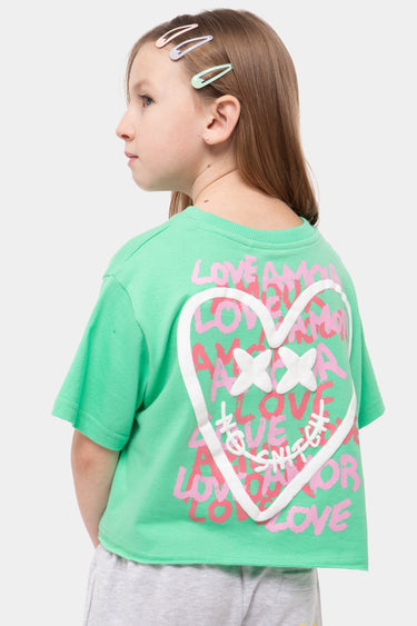 T-shirt Jilona Vert porté par une fille, vue de dos, grand cœur blanc à croix et inscriptions Love Amor roses