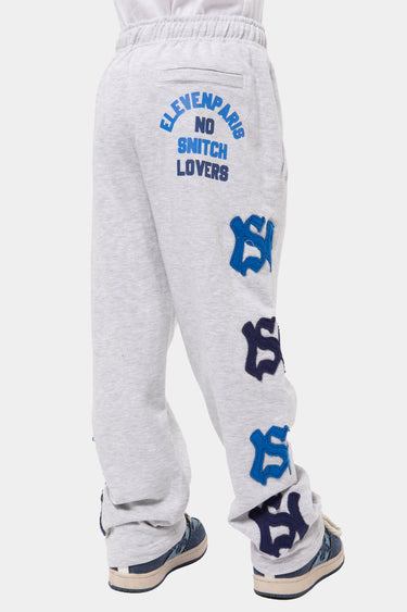 Jogging John Gris Chiné porté de dos, inscription Eleven Paris No Snitch Lovers sous la taille et lettres NY appliquées