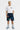 Short cargo Jolan Denim Bleu porté par un mannequin homme avec t-shirt blanc, fleurs colorées, baskets bleues, vue de face