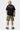 Short cargo Jolan Kaki porté de dos par un mannequin homme avec t-shirt noir Parisian Tour No Snitch, fleurs colorées