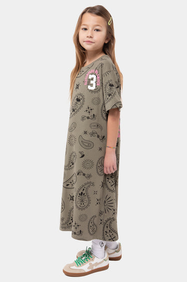 Robe Jonquille Kaki à motif paisley noir portée de profil par une fille, numéro 3 rose et blanc sur la poitrine