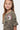 Robe Jonquille Kaki à motif paisley noir en gros plan sur une fille, numéro 3 blanc et inscription rose sur la poitrine