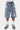 Short Jordan Bleu en jean délavé porté de face, ceinture à passants, fleurs de lys blanches, bleues et marine