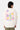 Sweat à capuche Josie Écru porté de dos par un mannequin homme, inscription rose Make Art Make Love et fleurs pastel