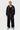 Jogging Journey Noir porté par un mannequin homme blond avec sweat zippé assorti à cordons colorés, baskets bleues