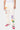 Jogging Joviel Écru porté de face par un mannequin, patchs fanion et badges, lettre E violette et fleurs, baskets roses