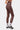 Legging de sport Jet Léopard porté de trois quarts dos, détail de la couture latérale et chaussettes blanches imprimées