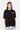 T-shirt Juicy Noir oversize porté de face par une mannequin femme, logo Eleven blanc et rose sur la poitrine, jean clair